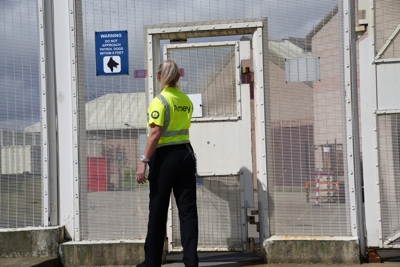 Amey employee standing in front of a secure gate