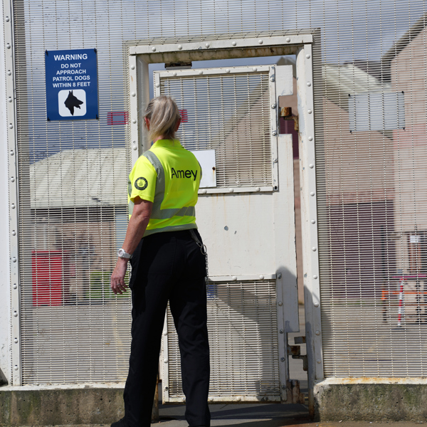 Amey employee standing in front of a secure gate