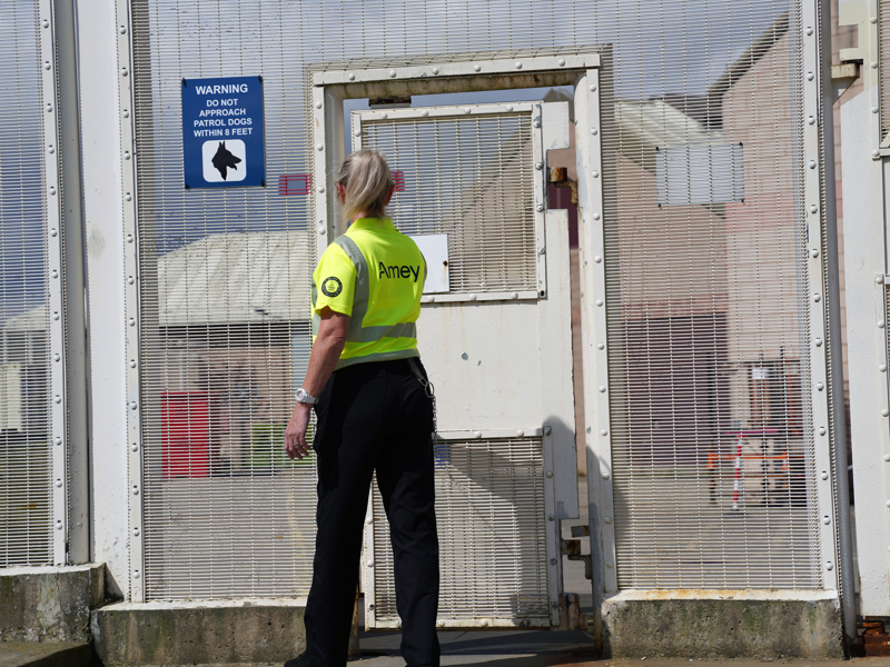 Amey employee standing in front of a secure gate