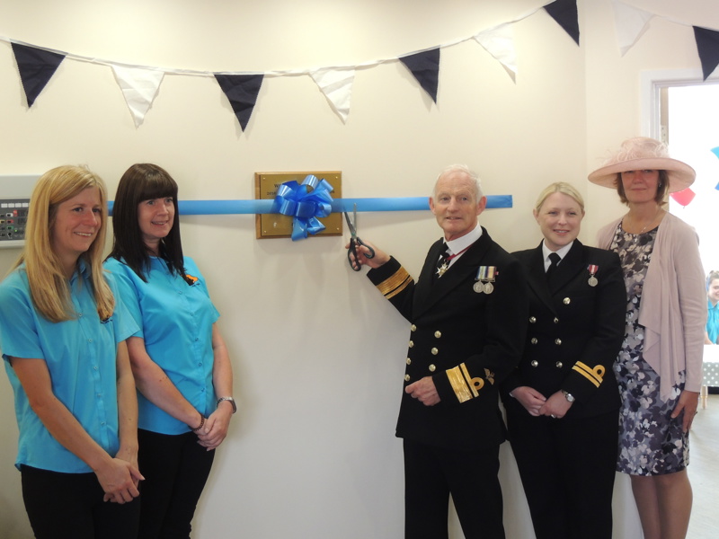Royal Navy personnel cutting a blue ribbon at a libor funded nursery.