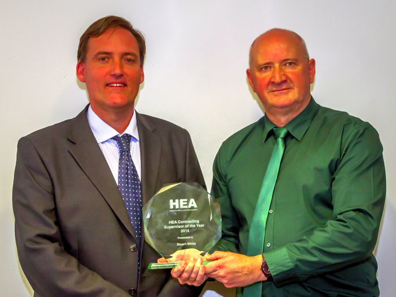 Image of two men holding an award.