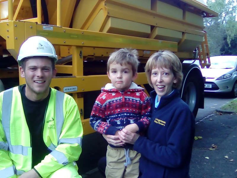 Image of nursery employee and child, with Amey employee in front of a gritter names 'Prince'.