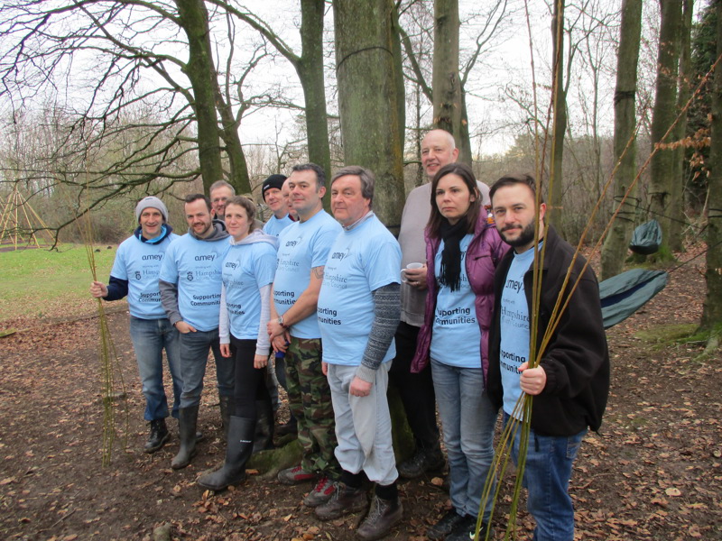 Image of Amey employees stood in a woodlands area.