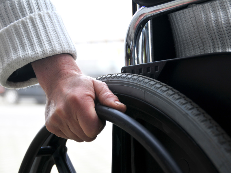 Up close image of a wheelchair user pushing their chair.