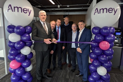 Amey employees cutting a ribbon to celebrate the Belfast office opening