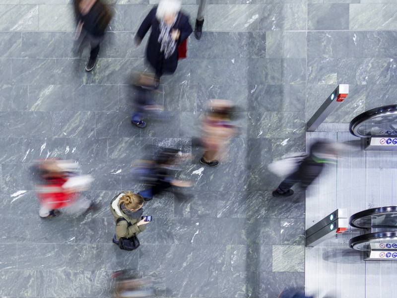 aerial mage of people walking at speed on a pavement