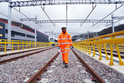 A woman in PPE on a rail track