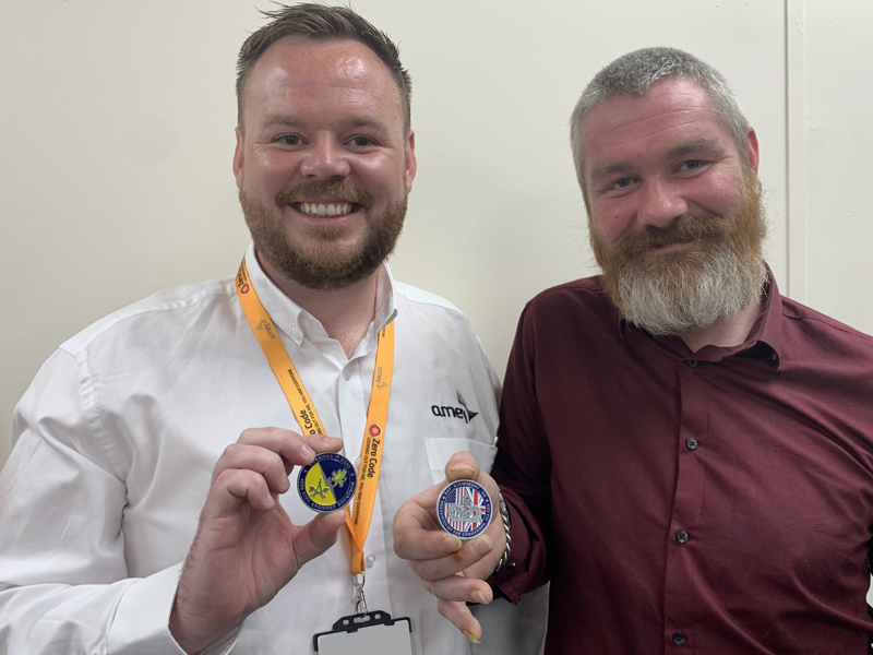 Image of two male Amey employees holding medals.