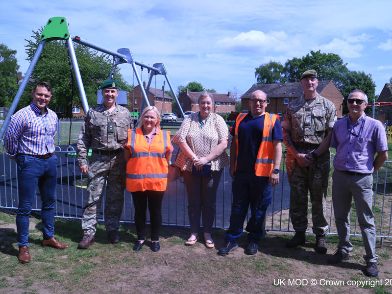 Image of Amey and military personnel in front of a children's playground.