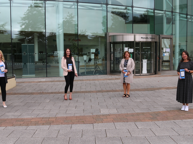 Image of four Amey employees, social distancing in front of a glass building.