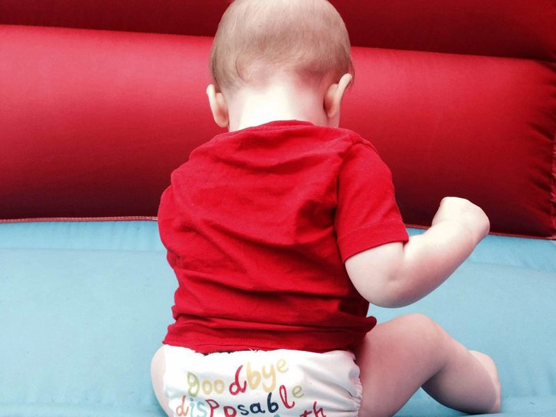 Image of a baby sat on a bouncy castle.