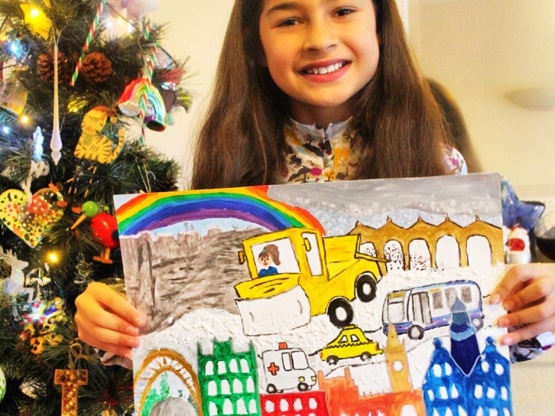 Image of Freya Siddiqui, age 11, holding her 1st prize picture of a snow plough.