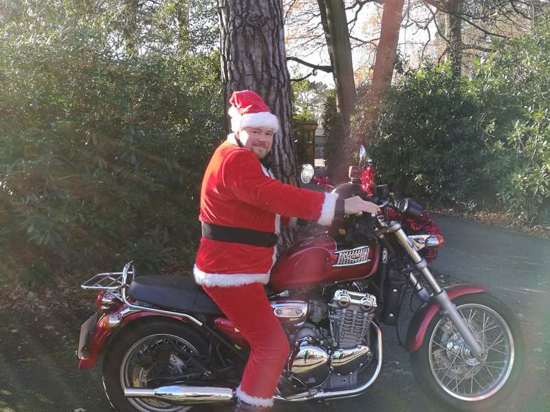 Image of a man dressed as Santa on a motorcycle.