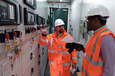 Amey employees wearing PPE, in a control room.