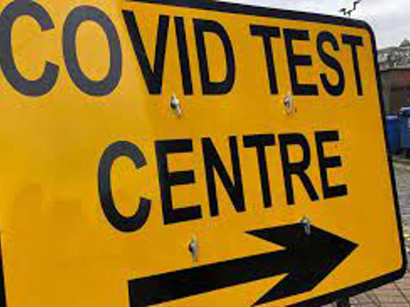 Image of a yellow covid test centre sign.