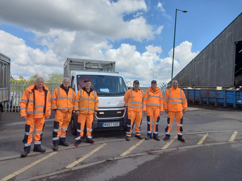 Six male Amey employees, in PPE standing in front of a van.