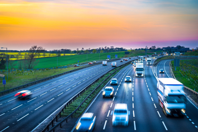 Cars on a highway, with a sunset background