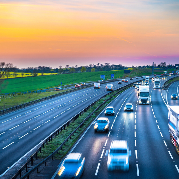 Cars on a highway, with a sunset background