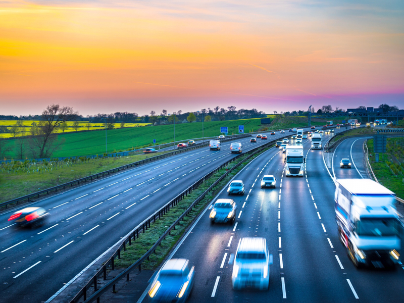 Cars on a highway, with a sunset background