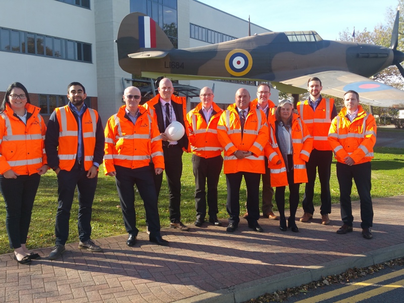 Amey employees in PPE, stood in front of an RAF aircraft.