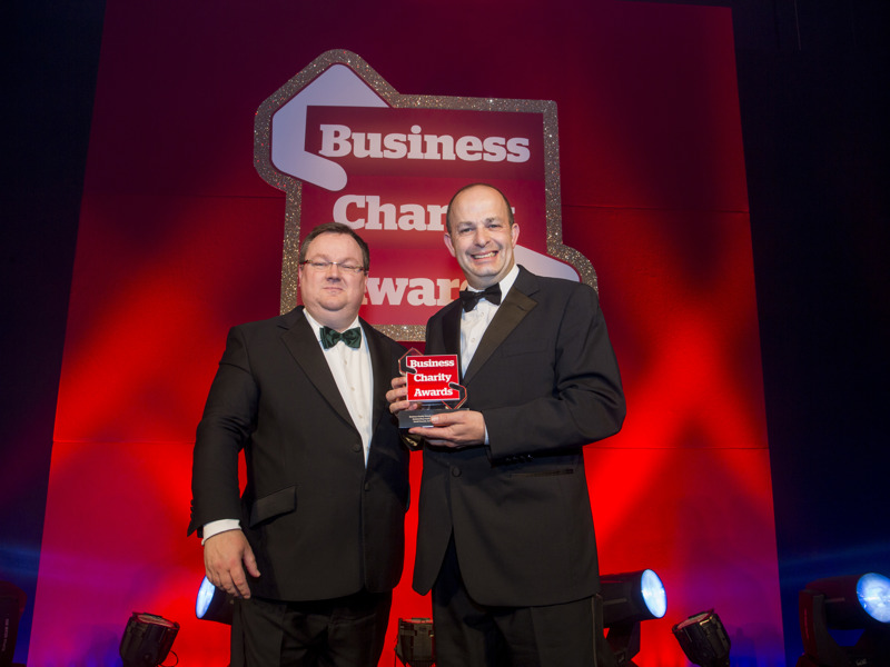 Image of David Fawcett holding an award for Business charity.