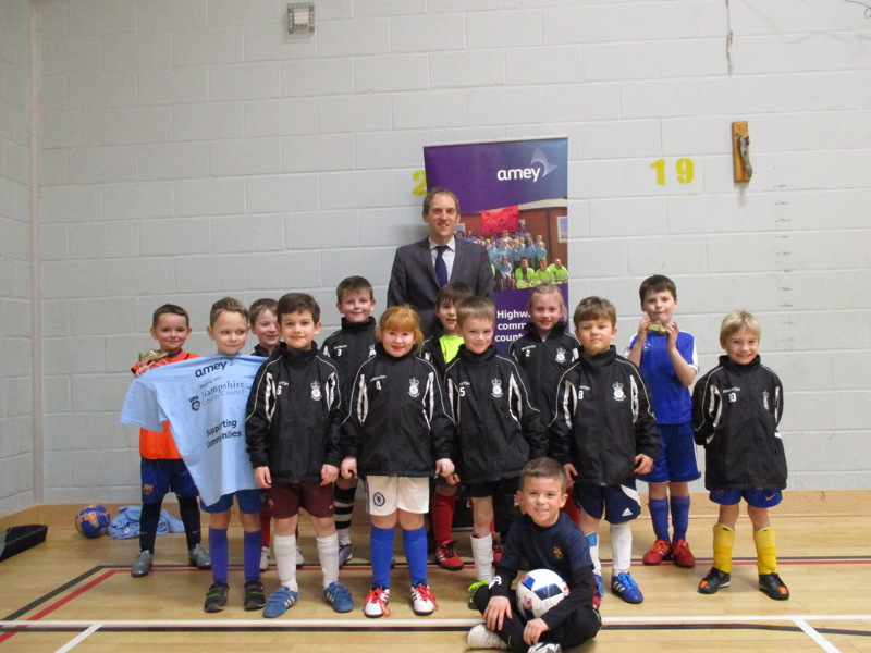 Image of an Amey employee with a children's football team.