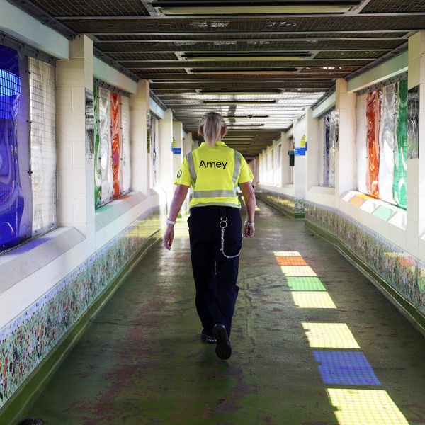 An Amey employee with their back towards us, walking