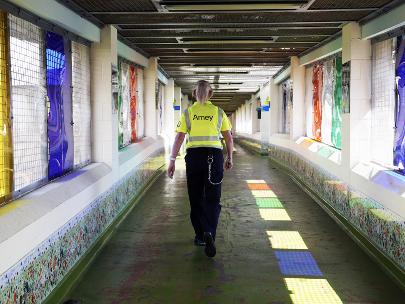 An Amey employee with their back towards us, walking