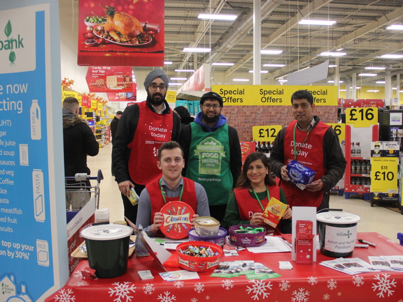Amey employees helping at a Tesco foodbank stand.