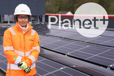 Lady in PPE in front of solar panels