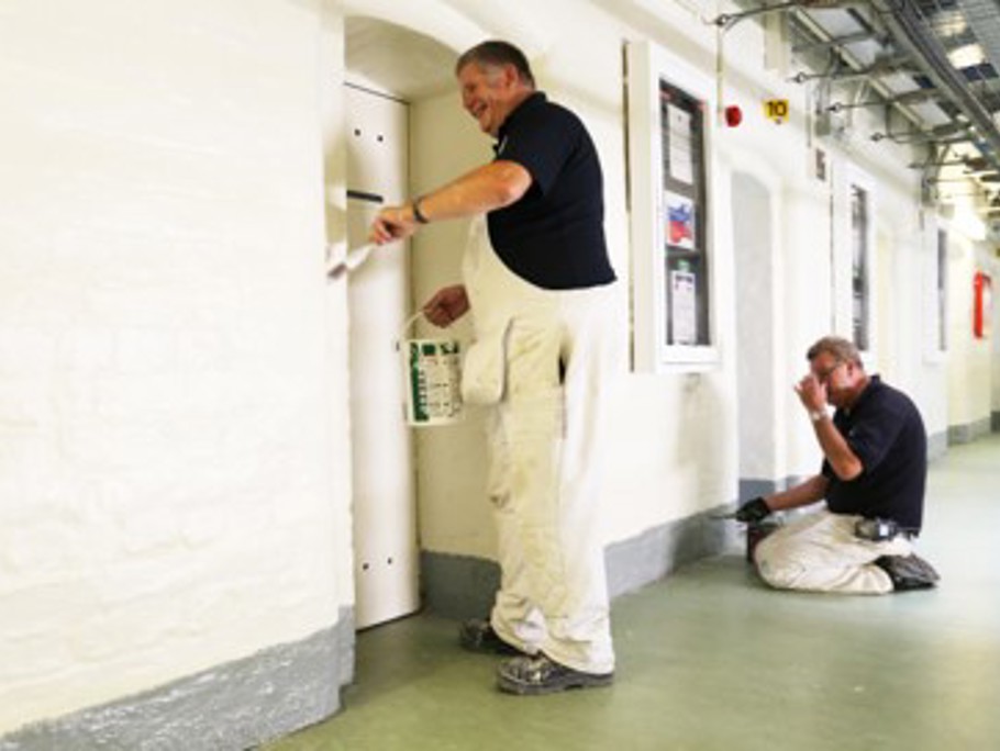 Image of Amey employees painting a prison hallway