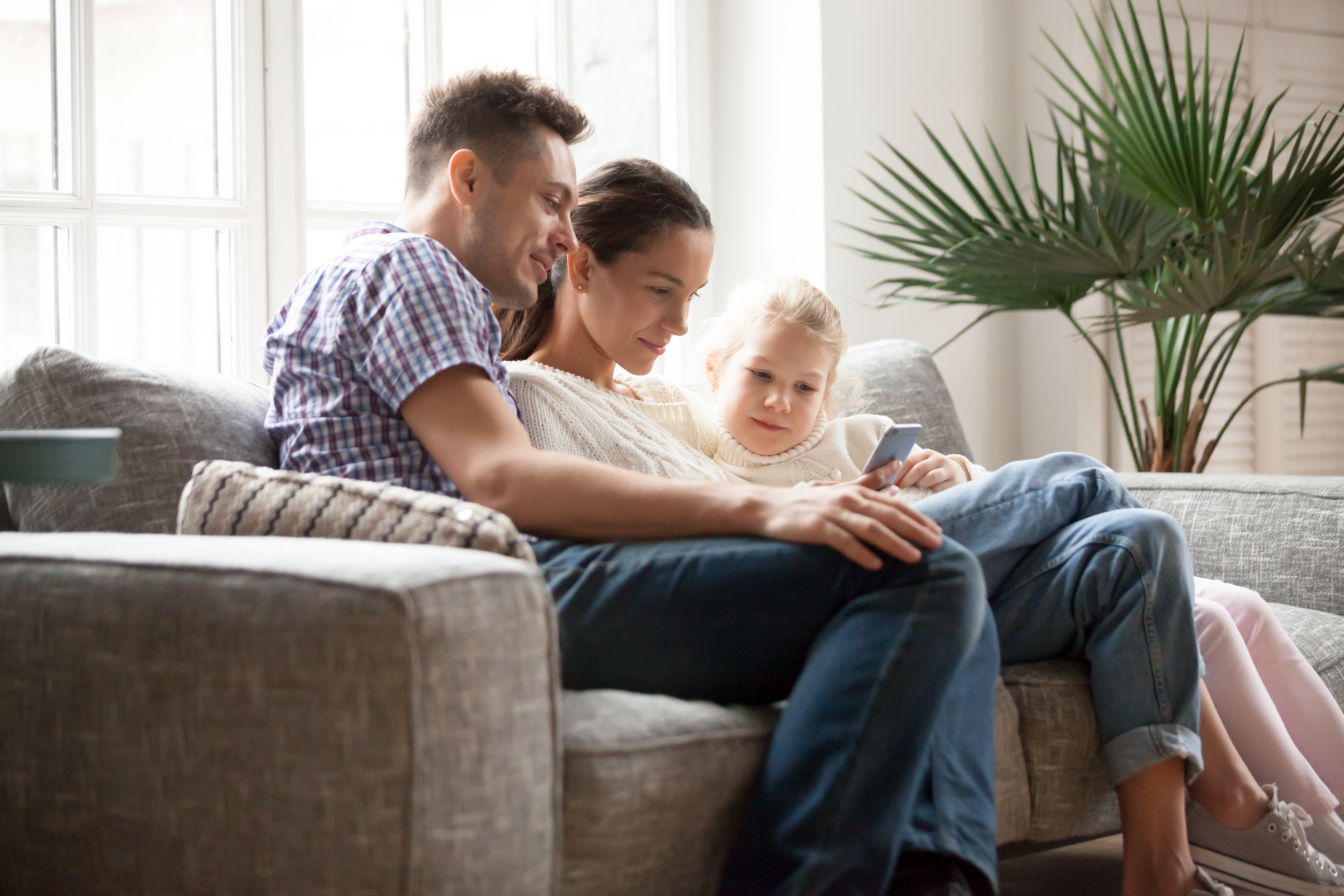 Image of a family at home on the sofa