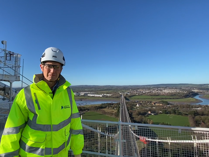 A man wearing safety equipment stood at the top of the Severn bridges.