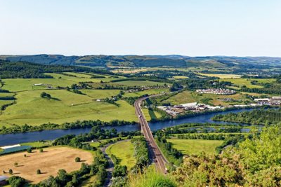 Ariel view of a bridge over a river surrounded by fields.