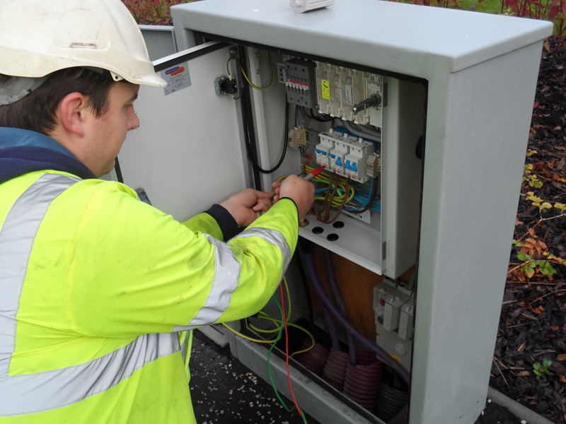 Image of an Amey employee carrying out work on a streetlight box.