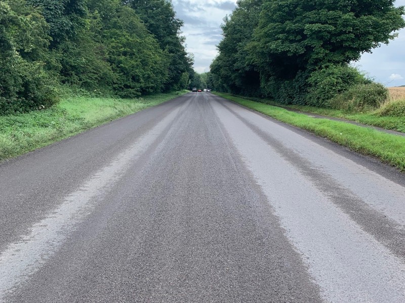 Image of a new road surface, along a rural road.